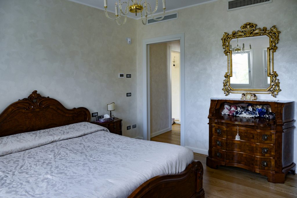 Camera da letto con arredi classici e pavimento in legno.