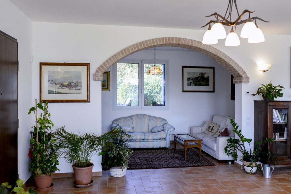 Zona relax con arco in mattoni e pavimento in cotto.