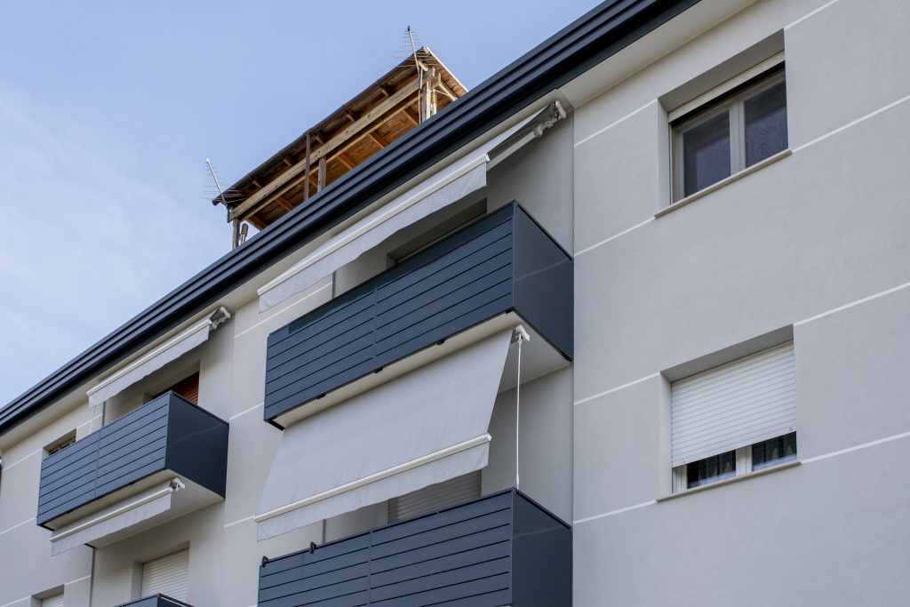 Facciata di un edificio residenziale con schermature grigie.