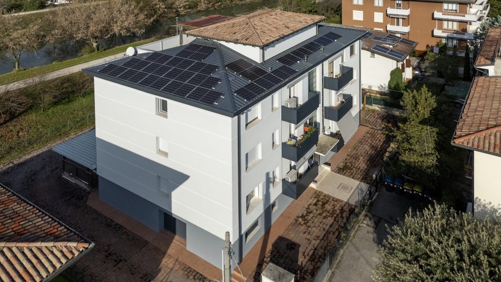 Condominio con facciate chiare, balconi e pannelli fotovoltaici.