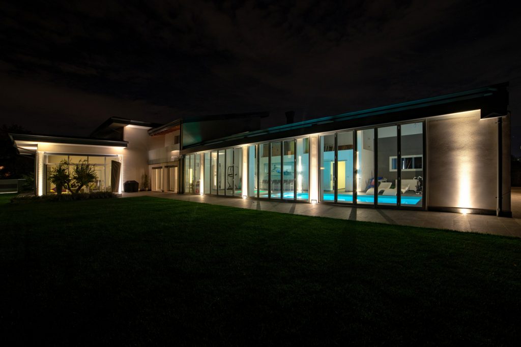 Fronte vetrato illuminato di sera con giardino — Fontaniva (PD)